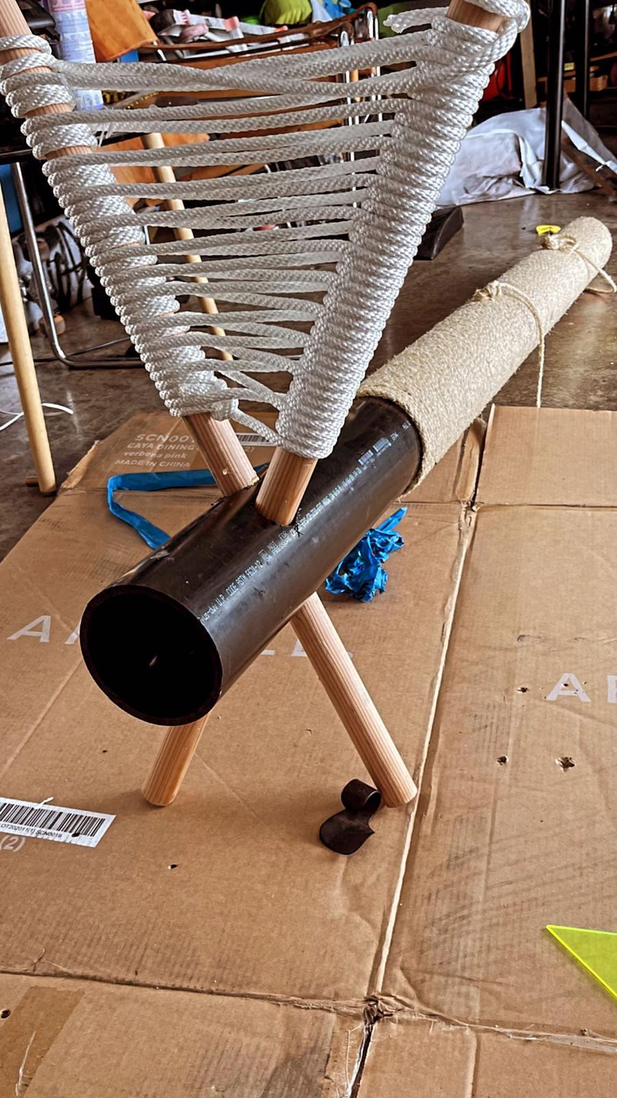 Side view of the cat tree mid-assembly with the woven hammock attached and the column partly wrapped.